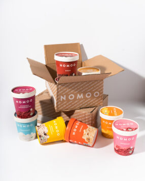 Das Bild zeigt NOMOO-Eis, zum Teil in einem Versandkarton.