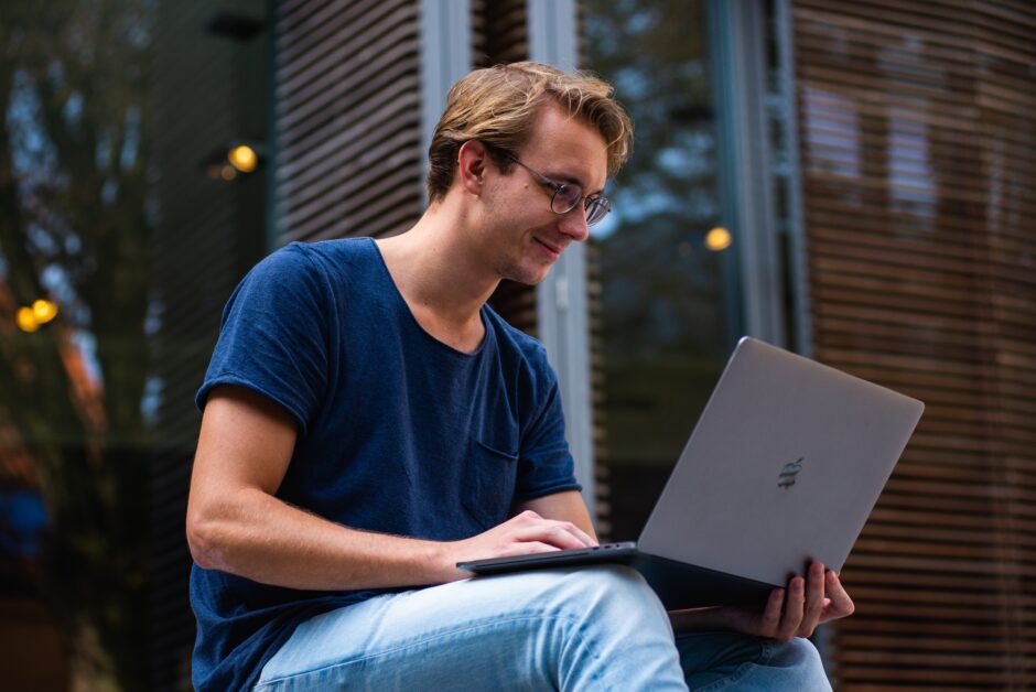 Ein junger Mann sitzt an einem Laptop