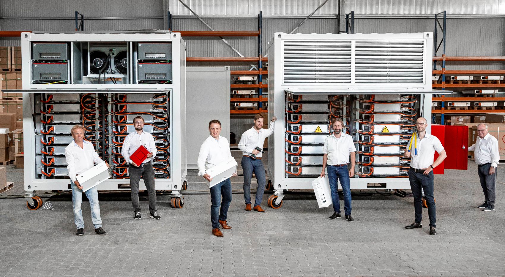 Team von Fenecon, im Hintergrund sind die Speichersysteme von Fenecon zu sehen.