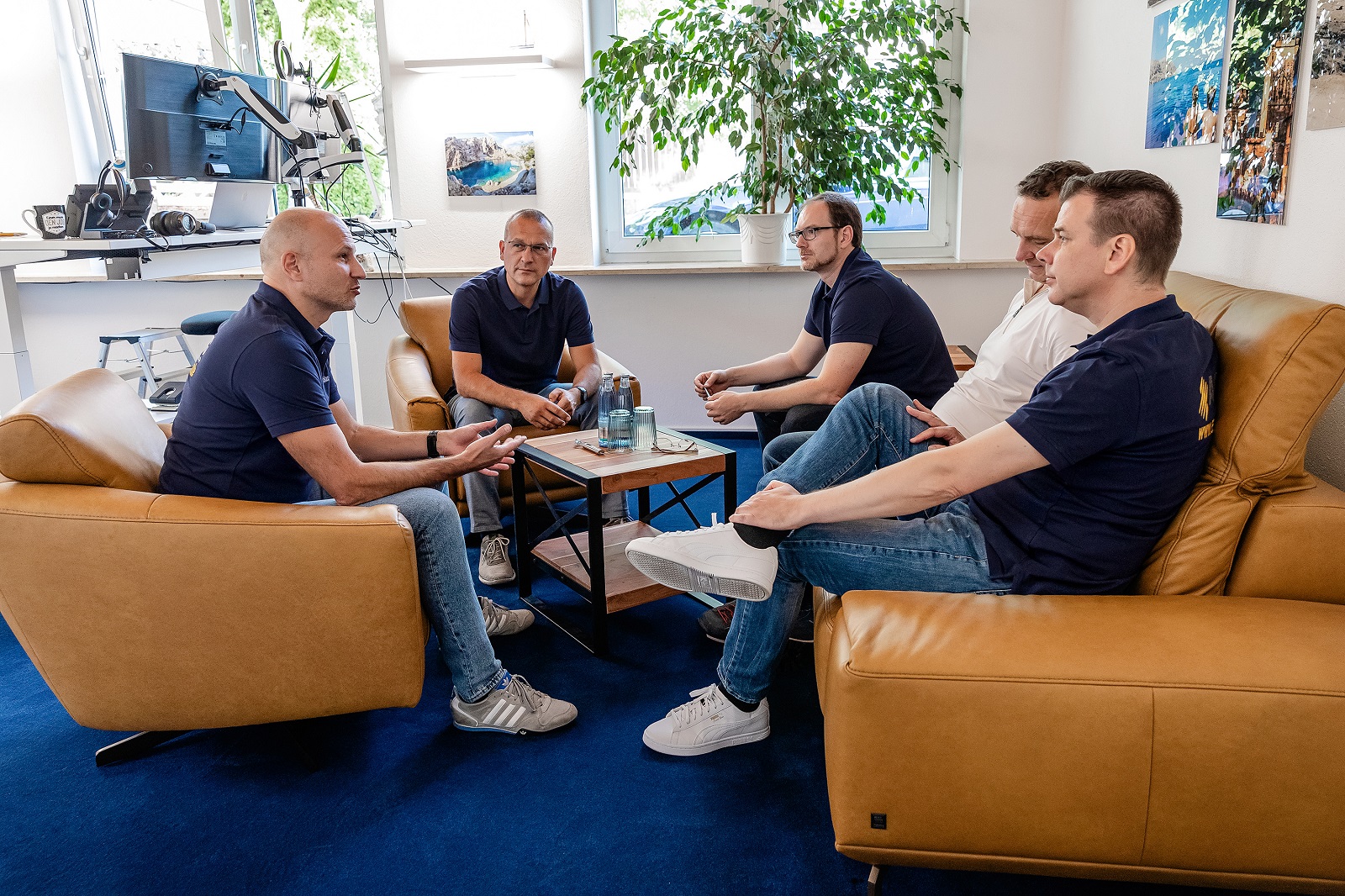 Mitarbeitende der ASG SolarInvest GmbH diskutieren in einem Büro.