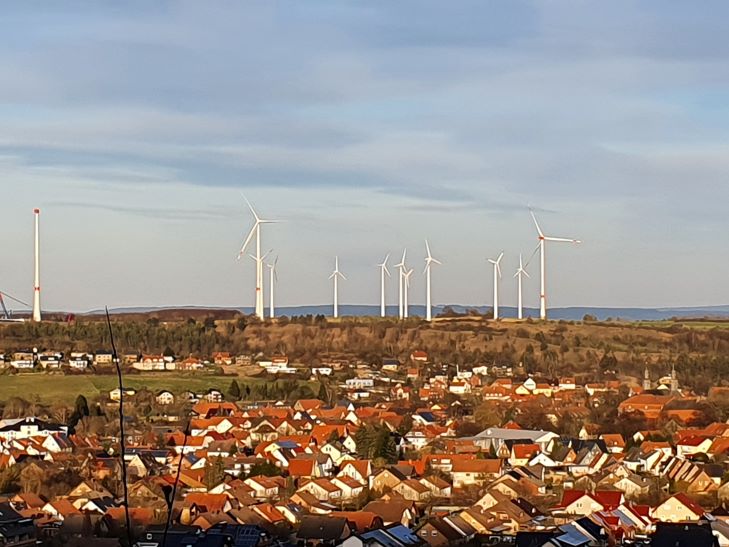 Windpark Willebadessen mit 14 Windrädern (vor Repowering) im Hintergrund mit dem Ort im Vordergrund in der Abendsonne