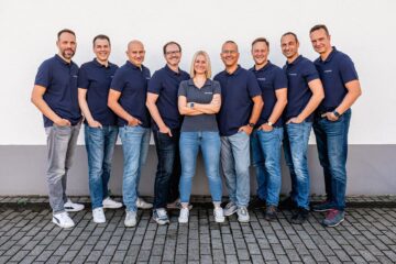 Teambild vom Kernteam der ASG Solarinvest, alle Mitglieder einheitlich im blauen Poloshirt, mit Logo