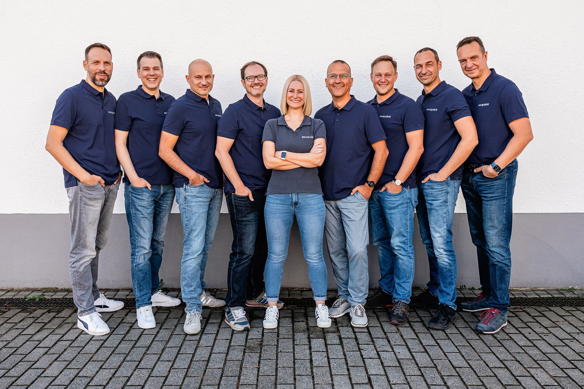Teambild vom Kernteam der ASG Solarinvest, alle Mitglieder einheitlich im blauen Poloshirt, mit Logo