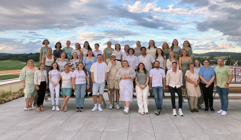 Das gesamte Team der littlebigFuture steht zusammen. Es sind mindestens 25 Personen, die alle freundlich in die Kamera schauen. Blauer Himmel ist im Hintergrund zu sehen sowie vereinzelnde Wolken.