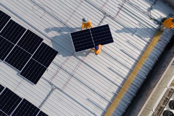 Bild von oben auf ein Flachdach, auf dem eine Solaranlage montiert wird.