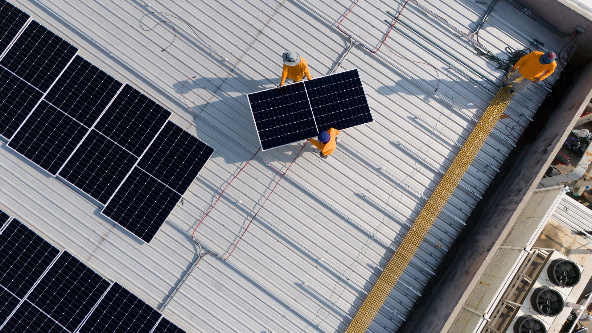 Bild von oben auf ein Flachdach, auf dem eine Solaranlage montiert wird.